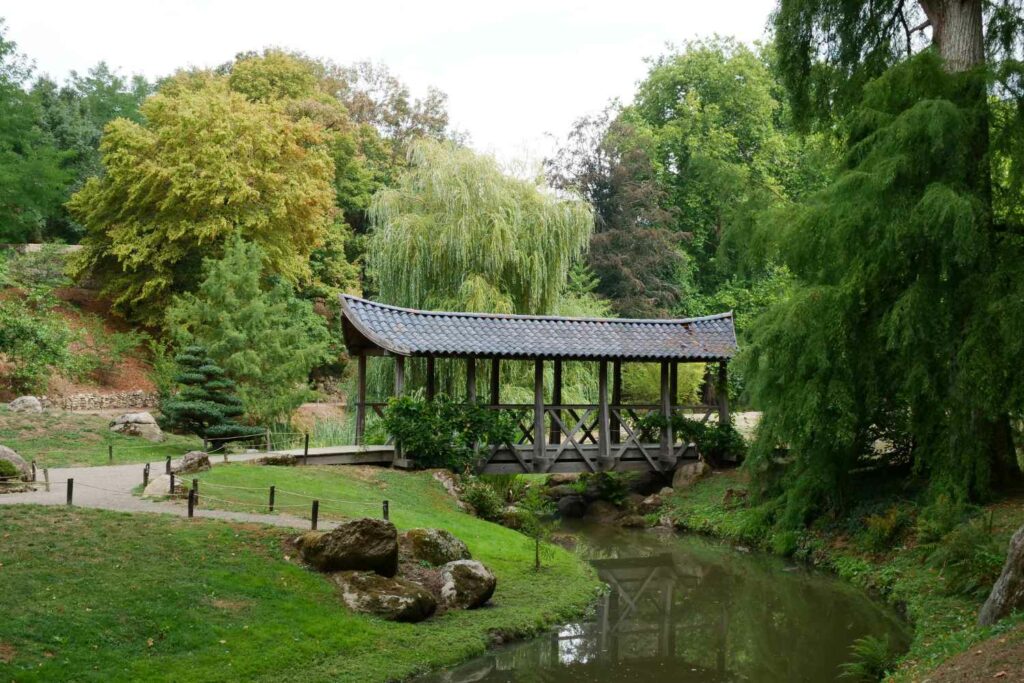 paysage du parc oriental de maulévrier, avec vue sur la rivière et un pont en bois